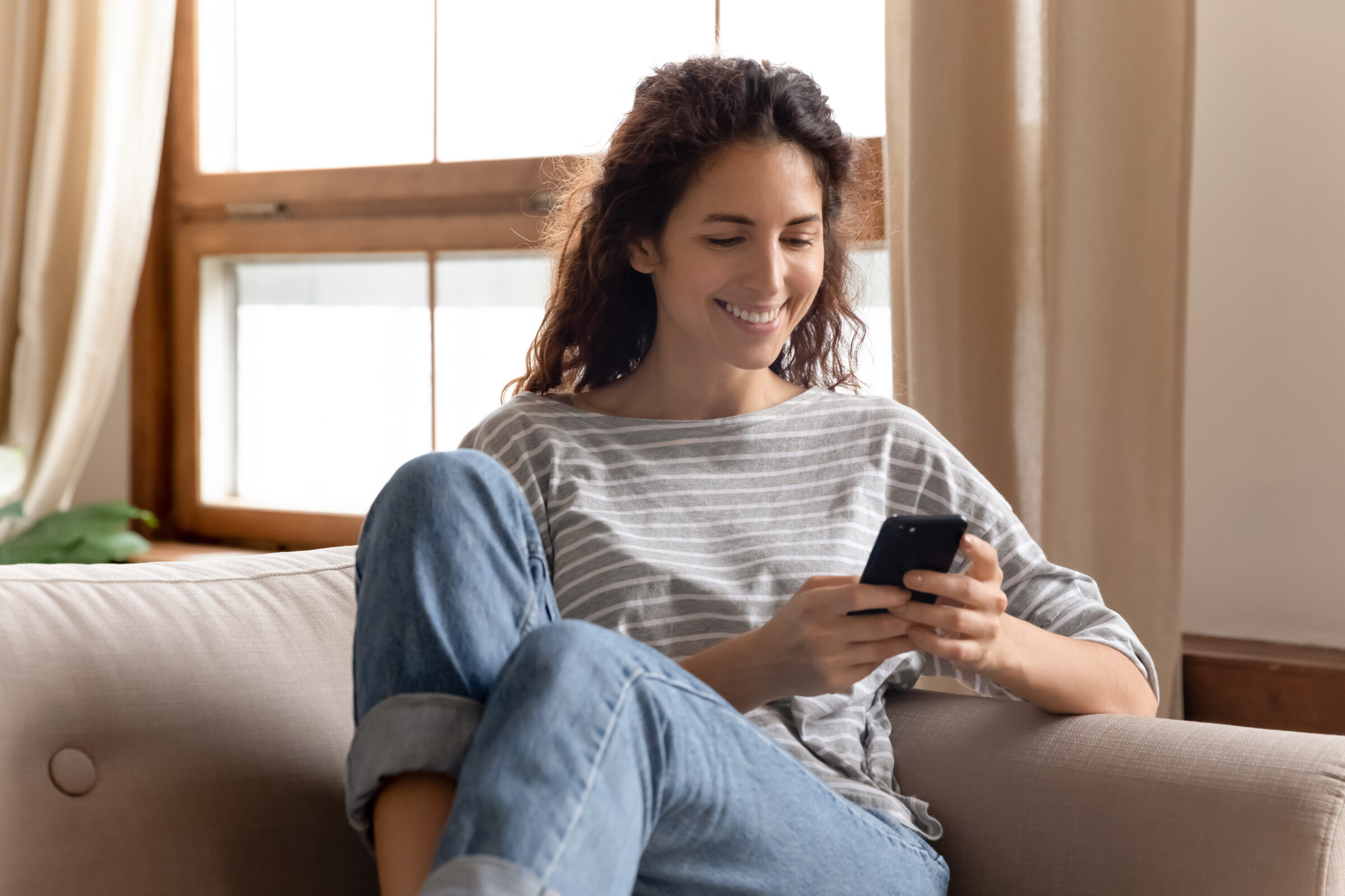 Young millennial scrolling through social media with her phone